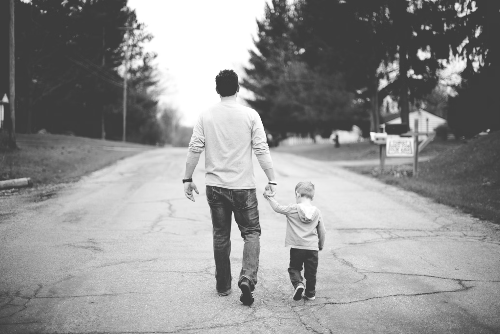 Father and son photo in black and white walking down the street