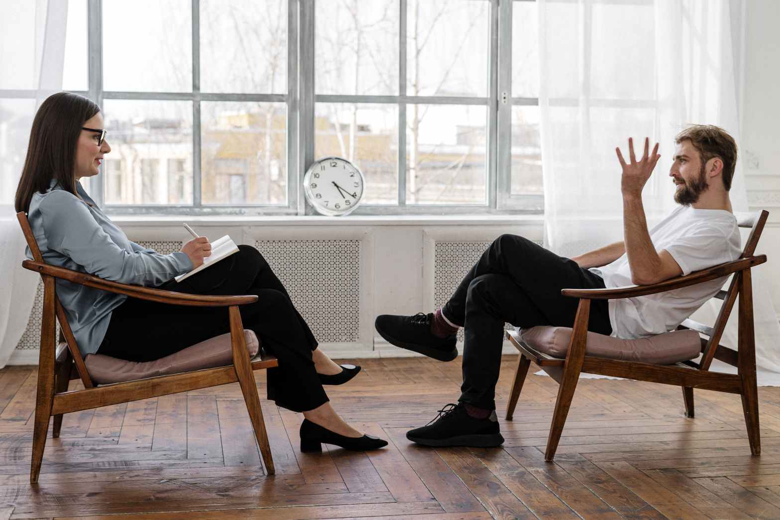 two people talking to each other while sitting on a chair psychology